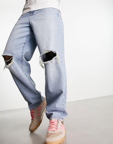 Jeans ampi lavaggio chiaro con strappi sulle ginocchia - ASOS DESIGN - Modalova