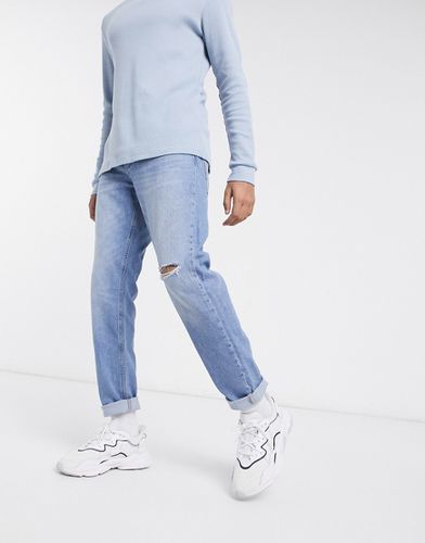 Jeans affusolati con strappo sul ginocchio lavaggio medio brillante - ASOS DESIGN - Modalova