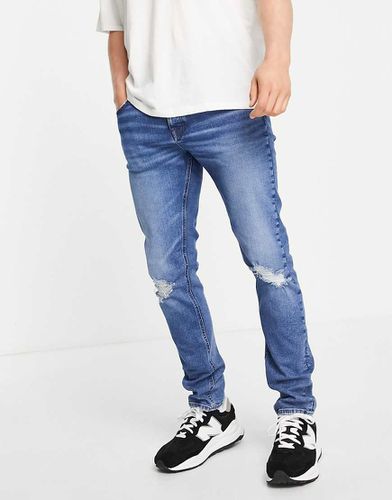 Jeans skinny lavaggio scuro con strappi sulle ginocchia - ASOS DESIGN - Modalova