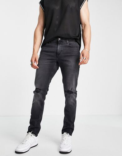 Jeans slim elasticizzati slavato con strappi sulle ginocchia - ASOS DESIGN - Modalova