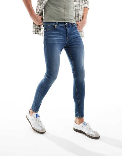 Jeans spray power stretch lavaggio medio - ASOS DESIGN - Modalova