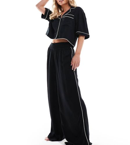 ASOS DESIGN Petite - Pantalon de pyjama ample et près du corps en tissu ultra doux avec passepoil contrastant - Asos Petite - Modalova
