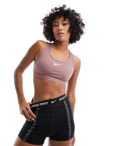 Reggiseno sportivo a sostegno medio in tessuto Dri-FIT malva fumo con logo - Nike Training - Modalova