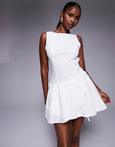 Cosie - Robe courte sans manches en broderie anglaise avec liens noués sur les côtés et ourlet à volants - Princess Polly - Modalova