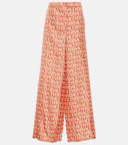 Pantalones anchos de seda con logo - Versace - Modalova
