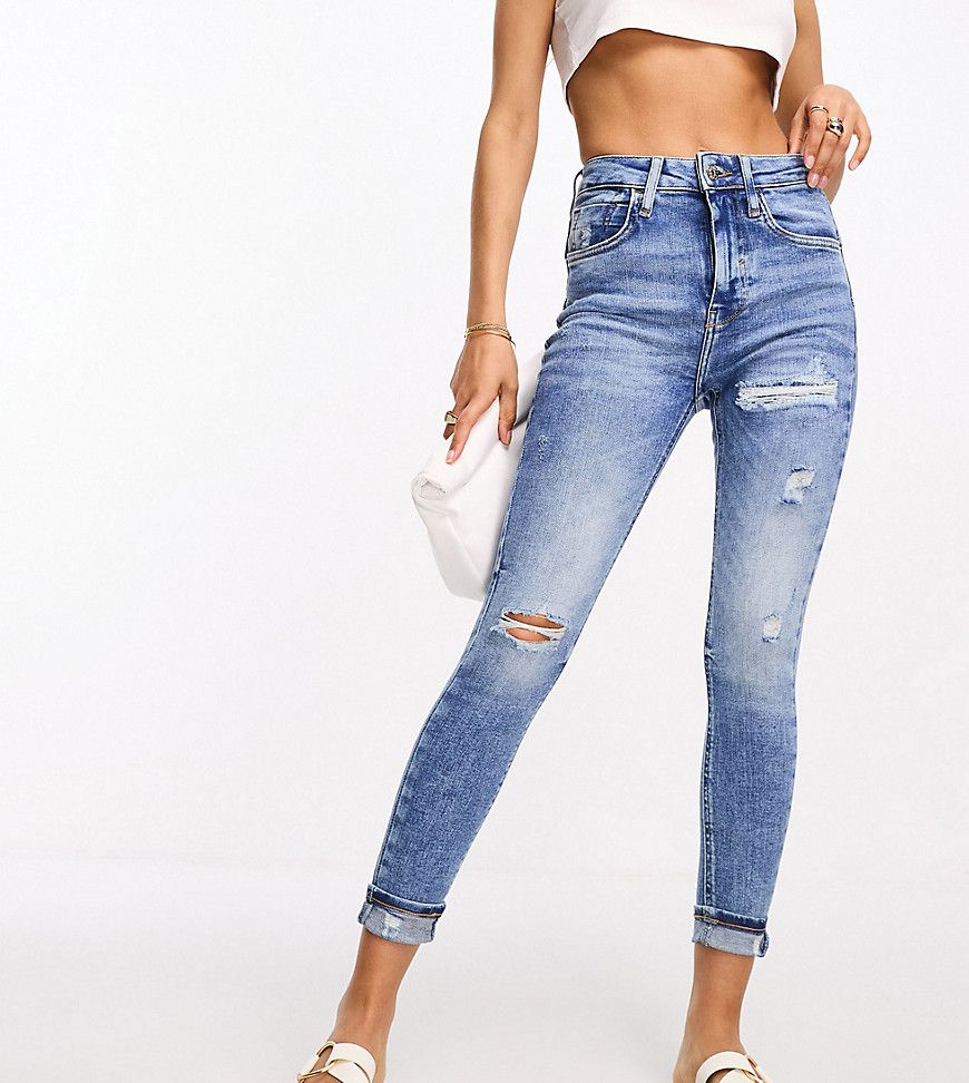 Jeans skinny modellanti a vita alta lavaggio medio con strappi sulle ginocchia - River Island Petite - Modalova